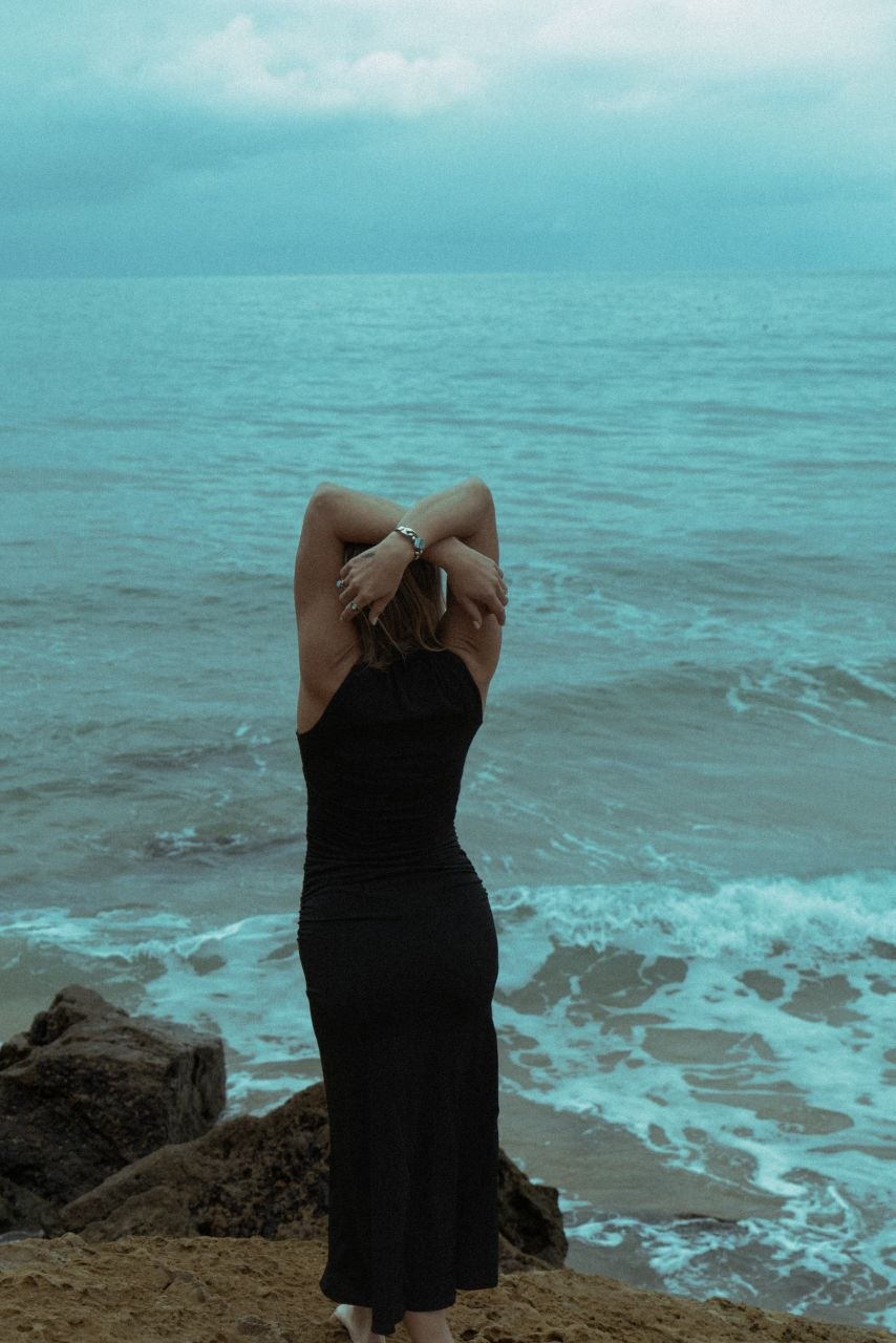 Maaike standing at the shoreline facing the ocean