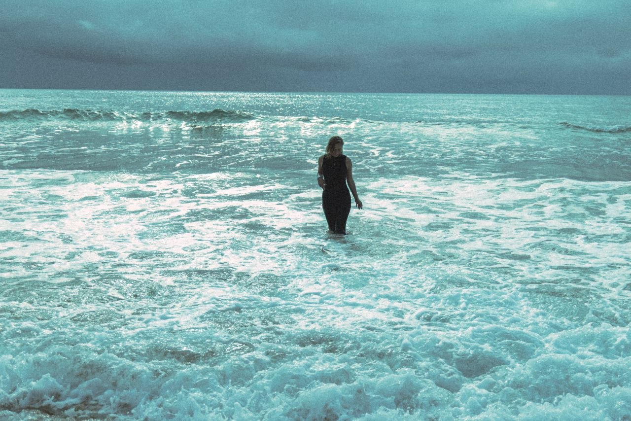 A person moving with the ocean at a rocky coastline